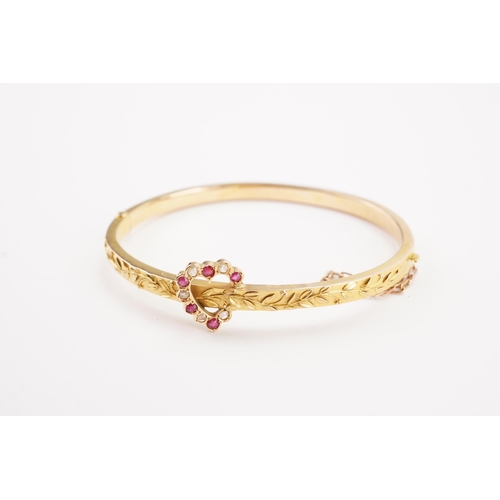 165 - A Victorian diamond and ruby set bangle, set in 15ct, with a diamond and ruby love heart decoration.... 