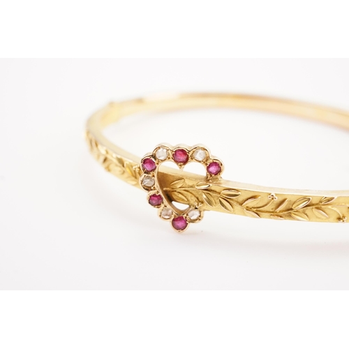 165 - A Victorian diamond and ruby set bangle, set in 15ct, with a diamond and ruby love heart decoration.... 