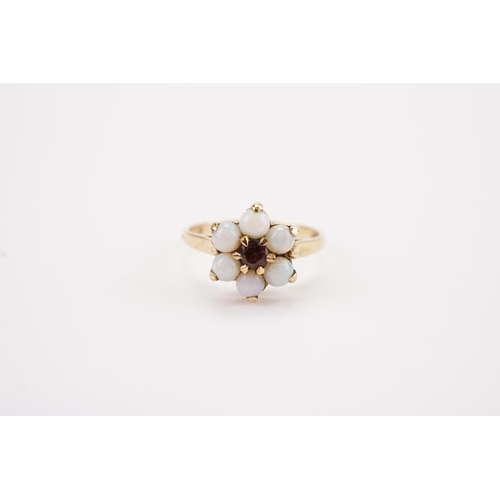 146 - A 9ct Gold Garnet & Opal set Dress Ring in the Flower design. Weighing: 2.2 grams. Size: M.