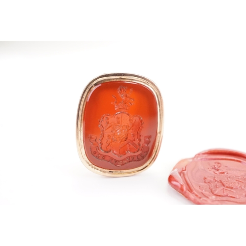 218 - A Georgian intaglio seal, mounted with a carnelian stone, depicting a family coat of arms. Weight 13... 