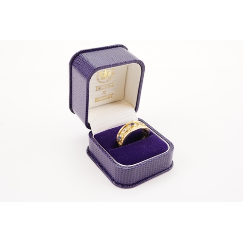 191 - A Brooks & Bentley Golden Jubilee 9ct gold ring in presentation box. Set with Garnets, Sapphires and... 