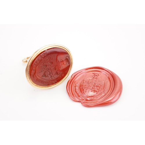 229 - A 14ct gold Georgian intaglio seal, set with a carnelian carved with a coat of arms, depicting a fis... 