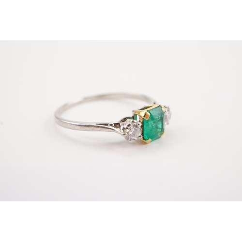 207 - A platinum mounted emerald and diamond set ring, set with a cushion cut emerald 5.4 x 6. Two diamond... 