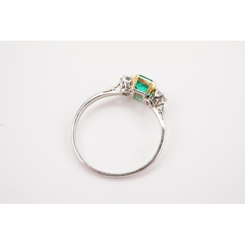 207 - A platinum mounted emerald and diamond set ring, set with a cushion cut emerald 5.4 x 6. Two diamond... 