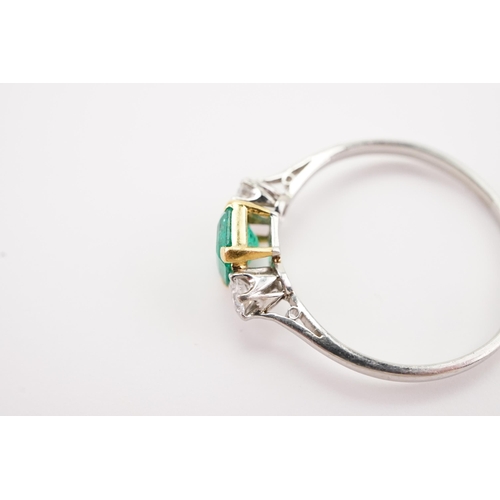 207 - A platinum mounted emerald and diamond set ring, set with a cushion cut emerald 5.4 x 6. Two diamond... 