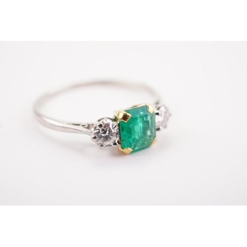 207 - A platinum mounted emerald and diamond set ring, set with a cushion cut emerald 5.4 x 6. Two diamond... 