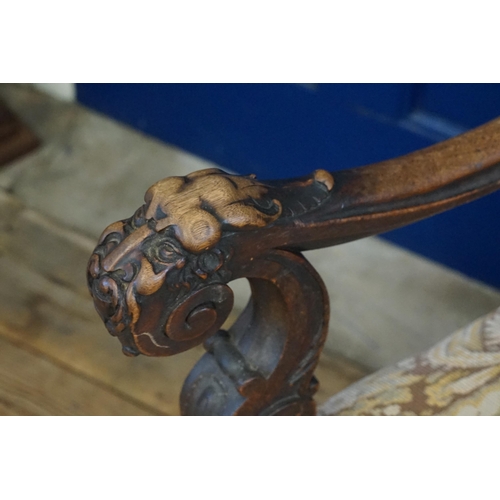 527 - An Irish designed Carved Mahogany Throne Chair decorated with Stylised Faces with Moustaches resting... 