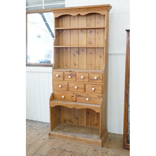 480 - A Pine Dresser fitted with a Dog Kennel Base, Three banks of graduated drawers with Porcelain handle... 