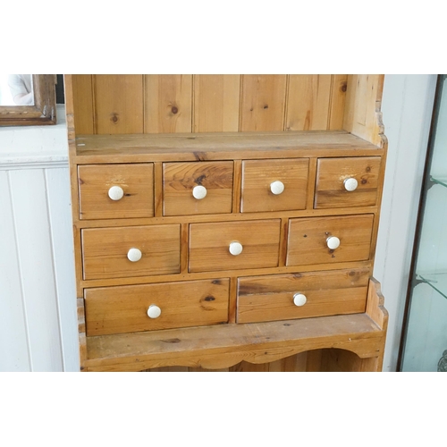 480 - A Pine Dresser fitted with a Dog Kennel Base, Three banks of graduated drawers with Porcelain handle... 