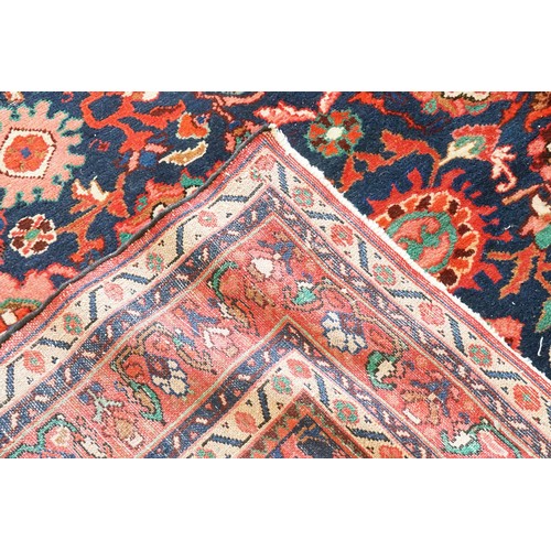 569 - A Red Ground All Over Floral Pattern & Twin Beige bordered Maltese Cross Rug. Measuring: 227cms x 16... 