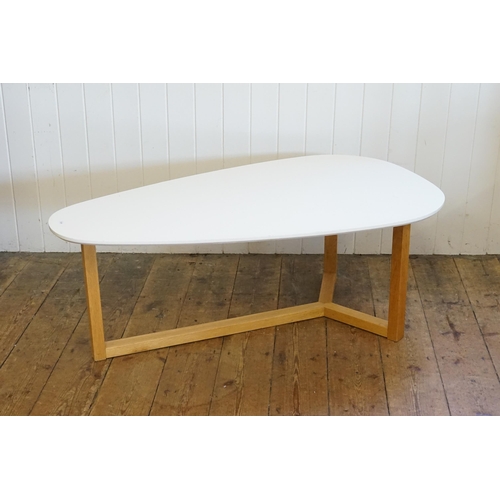 547 - A Melamine Topped Egg Shaped Coffee Table resting on an Oak Tri-Form Base. Measuring: 120cms long x ... 