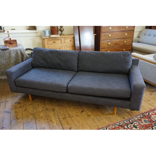 549 - A Low-Down Blue Twilled Covered Four Seater Settee with loose squab cushions. Measuring: 210cms acro... 