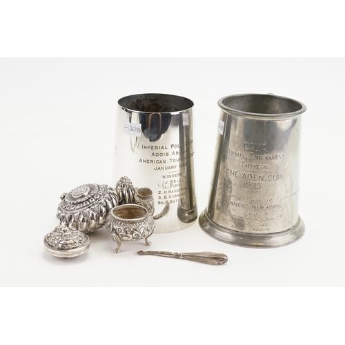 98 - A Silver coloured white metal Indian designed locket, along with similar pot and cruet, two tankards... 