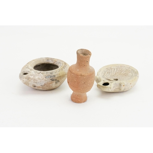 427 - Two ancient Egyptian terracotta oil lamps, one in the shell design, along with a miniature stone car... 