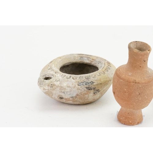 427 - Two ancient Egyptian terracotta oil lamps, one in the shell design, along with a miniature stone car... 