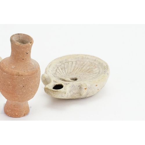 427 - Two ancient Egyptian terracotta oil lamps, one in the shell design, along with a miniature stone car... 