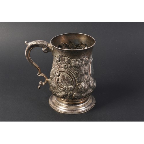 26 - A Georgian Silver Rococo Floral embossed Mug with a Flying Scroll Handle. Weighing: 321 grams.