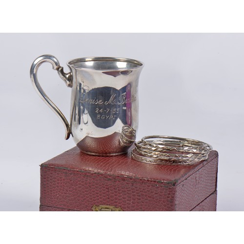 83 - A German Silver 835 marked engraved Mug, a Silver Christening Bangle & Egyptian Bangles.