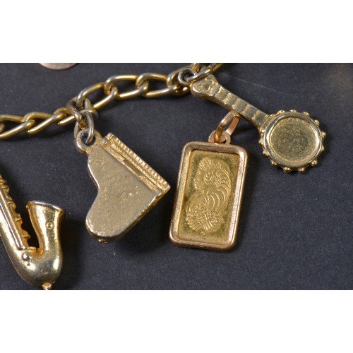 148 - A Small Gold Ingot (one Gram), a pair of masked Earrings & a Charm Bracelet.