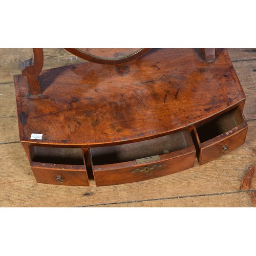 568 - A Regency Shield shaped Swing Framed Dressing Table Mirror in Mahogany fitted with three Drawers.