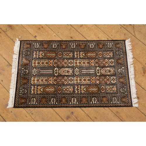 693 - A Black Ground Floral Medallion Bordered Five Run Multi Gulled Rug. Measuring: 97cms x 61cms.