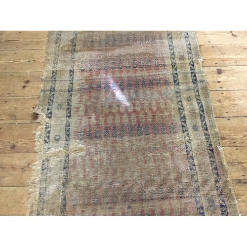 702 - An Antique Hand Made Persian Runner in Poor Condition. Measuring: 381cms x 101cms.