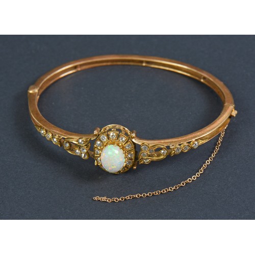 64 - A Lovely Victorian Ladies Gold Bangle inset with an Oval Opal surrounded by Twelve Eight Cut Diamond... 