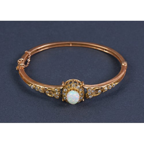 64 - A Lovely Victorian Ladies Gold Bangle inset with an Oval Opal surrounded by Twelve Eight Cut Diamond... 