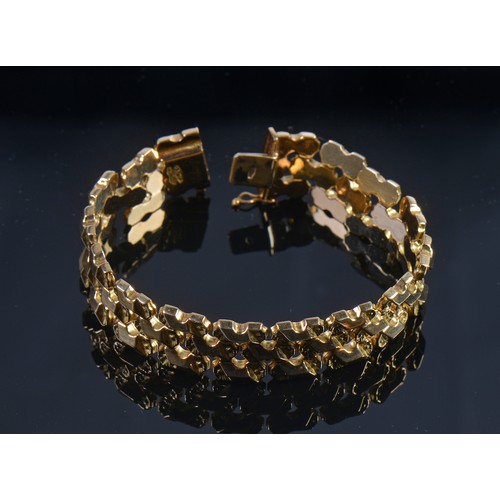 99 - A Ladies 18ct Gold Flexible Link Faceted & Floral Cut Bracelet. Weighing: 32 grams.