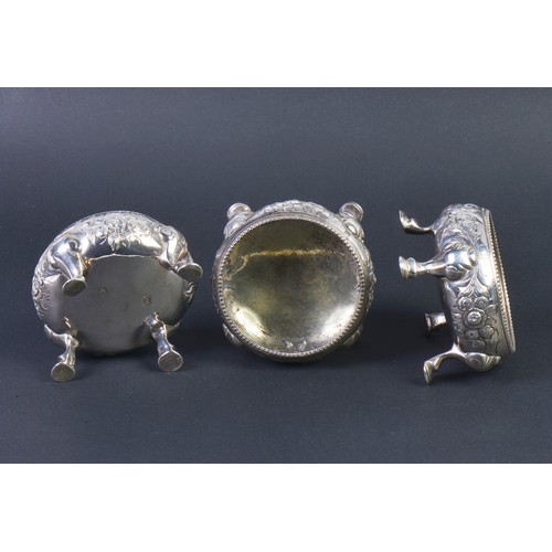 189 - A Set of Three Georgian Silver Rococo pattern Salt Cellars, London Q. Maker: (Rubbed). Weighing: 345... 