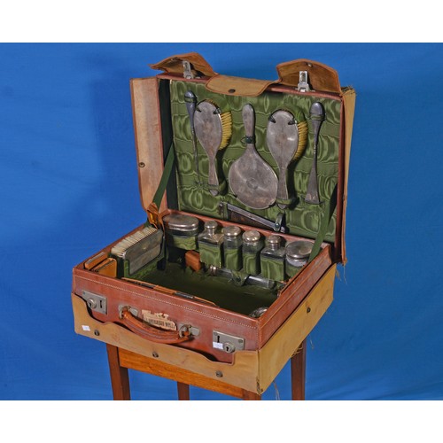 36 - A 1920s Leather Cased Travelling Vanity Case containing Silver mounted Mirror, Two Brushes, Shoe, Bu... 