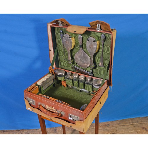 36 - A 1920s Leather Cased Travelling Vanity Case containing Silver mounted Mirror, Two Brushes, Shoe, Bu... 