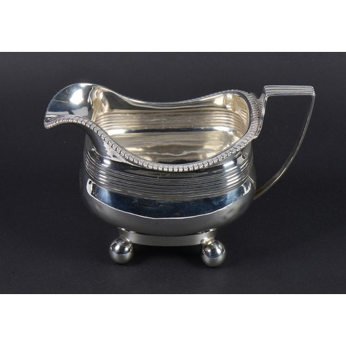 61 - A Silver Helmet shaped Georgian Milk Jug with gadrooned decoration resting on Ball Feet. Chester hal... 