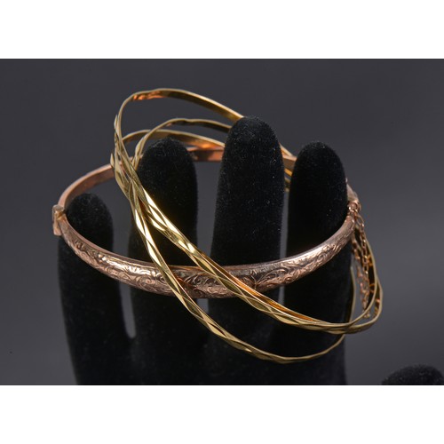 158 - A 9ct Gold engraved Bangle. Weighing: 4.2 grams. Along with Three Bangles bearing marks.