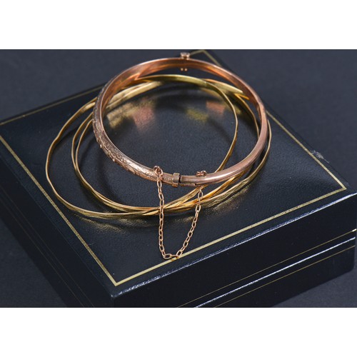 158 - A 9ct Gold engraved Bangle. Weighing: 4.2 grams. Along with Three Bangles bearing marks.