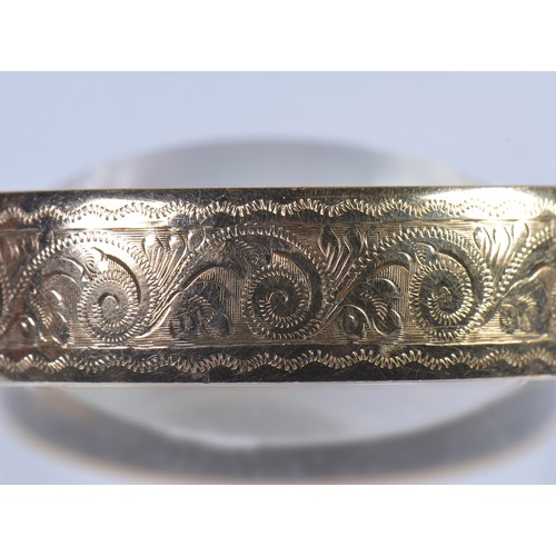 237 - A 9ct Gold Floral engraved Bangle with Safety Chain. Weighing: 12.7 grams. Along with one other Bang... 