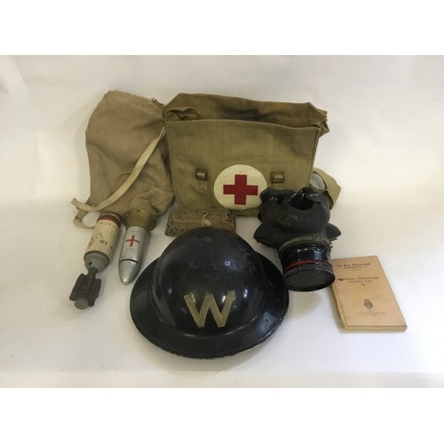 564 - A WWII Warden's Black Helmet, an Incendiary Bomb, Dressing, Handbook, etc.