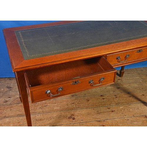 630 - An Oak Two Drawers Leather topped Writing Table resting on spade feet. Measuring: 122cms across x 77... 