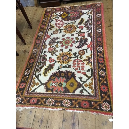 693 - A Vintage Persian Rug Ivory Field with Flowers within a Red Border. Measuring:205cms x 123cms.