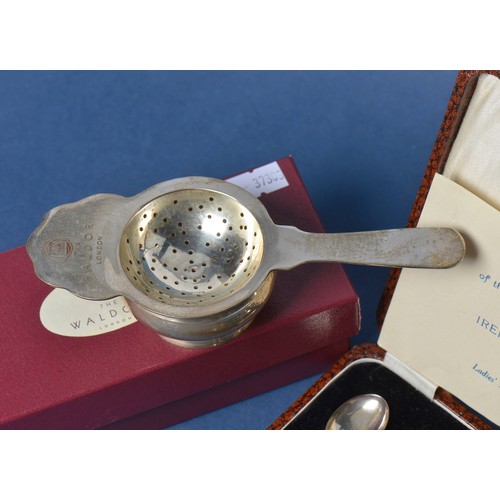 68 - A Set of Six Silver Bean Handled Tea Spoons & a Waldorf Hotel Tea Strainer with Base & Box.