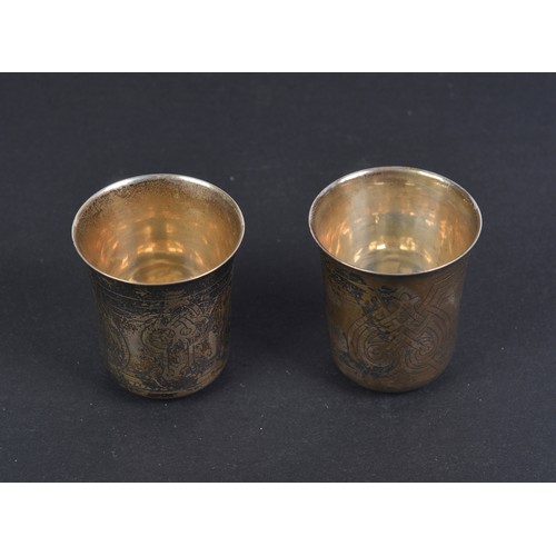 75 - A Pair of Russian Silver Vodka Tots with engraved decoration, marked 84BC1870 - St. George. Weighing... 