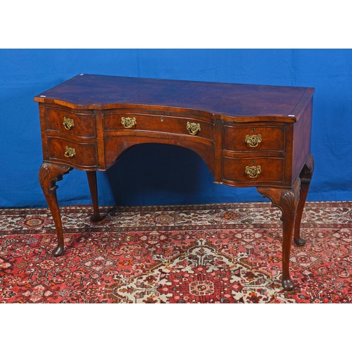 557 - A Queen Anne design Shaped Fronted Walnut & Cuban Mahogany Dressing Table resting on Carved Pad Feet... 