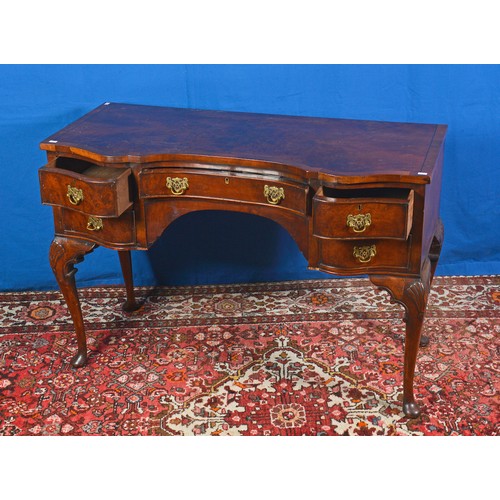 557 - A Queen Anne design Shaped Fronted Walnut & Cuban Mahogany Dressing Table resting on Carved Pad Feet... 