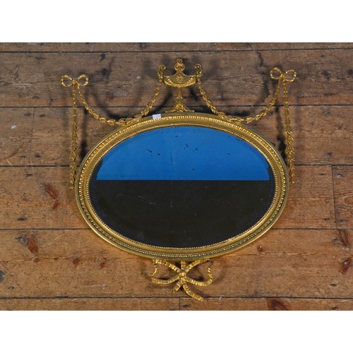 587 - A Regency Oval Wall Mirror decorated with a Vase & Swags & Bows dot egg & dart Husk Decoration. Meas... 