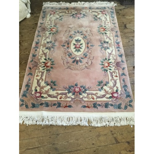 594 - A Salmon Pink Ground Chinese Floral decorated Cut & Shaped Fringe bordered Rug. Measuring: 200cms x ... 