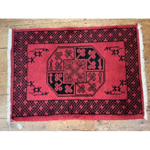 599 - A Rust Ground Single Bordered Central Key Rug. Measuring: 92cms x 65cms.