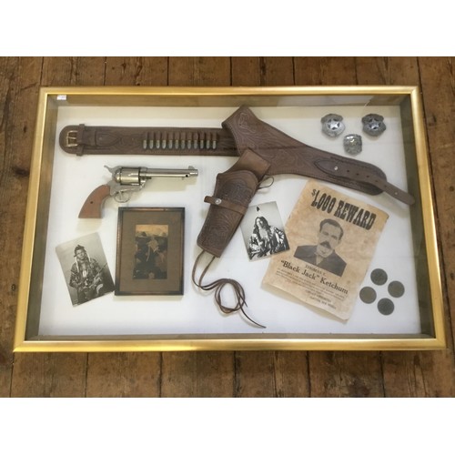 955 - A Collection of Replica Wild West Memorabilia Contained in a Glass Frame. Measuring: 92cms x 62cms.