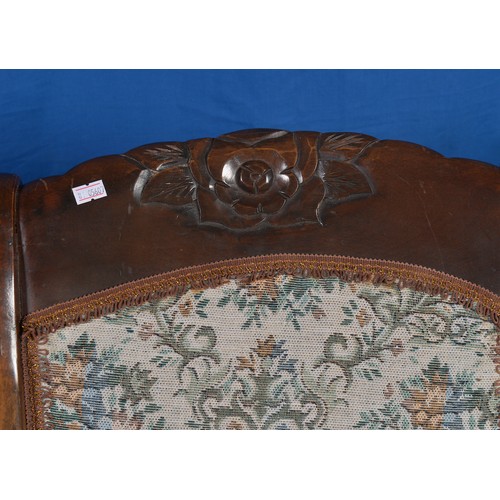 555 - A Beech Framed Rocking Chair with Carved Floral Crest & upholstered in Floral Tapestry.
