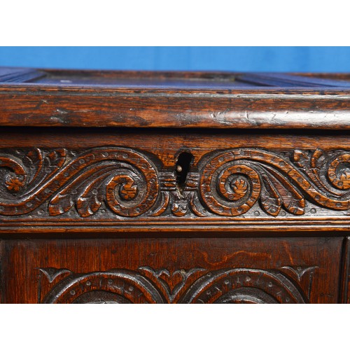 559 - An Antique Oak Coffer with three Carved panelled front, double panel ends & resting on squared lined... 
