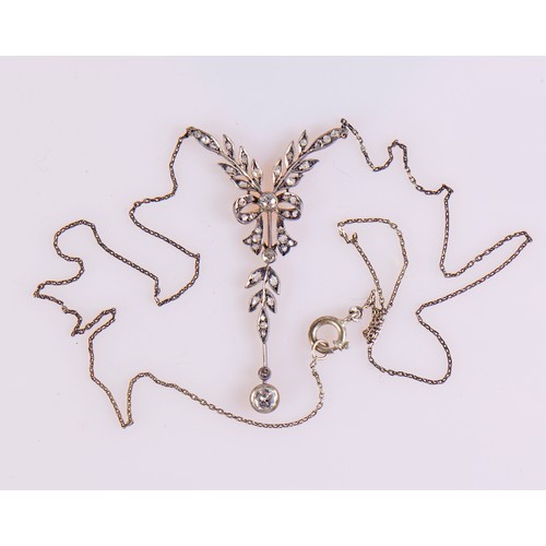 27 - An Edwardian diamond necklace featuring a delicate leaf and bow design, set with diamonds, the large... 